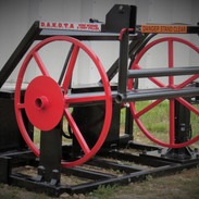 Image of a red and black skid steer attachment with DAKOTA sign on it