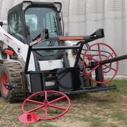 Image of a skid steer loader attaching a red skid steer attachment